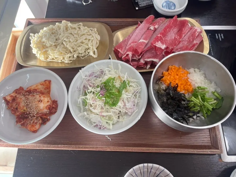 Table setting with dressed kimchi and salad side dishes