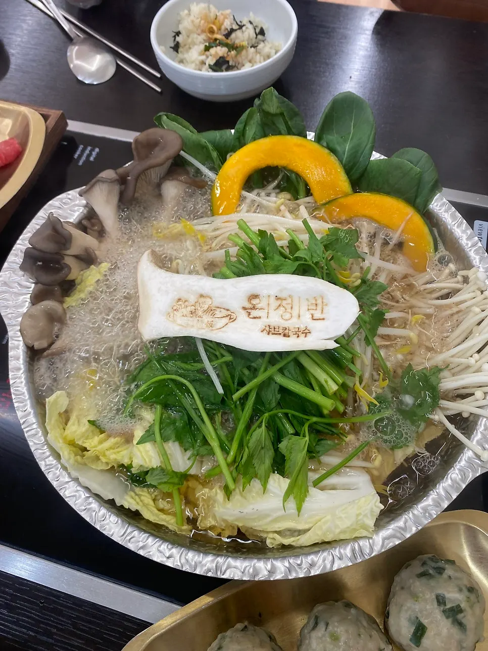 Shabu-shabu pot simmering with vegetables in broth