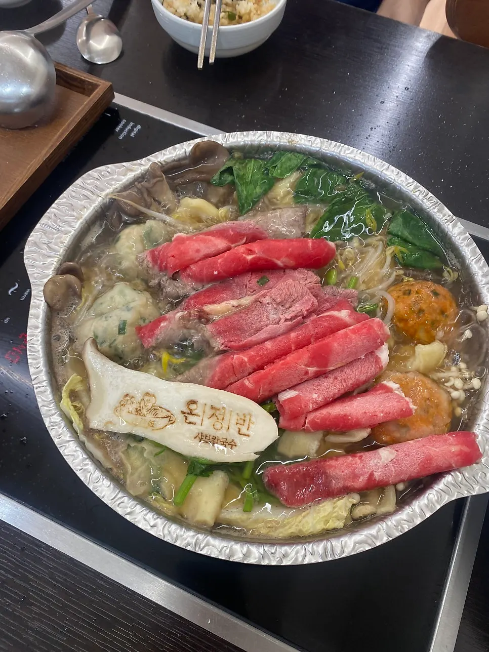 Scooping out shabu-shabu vegetables as they cook