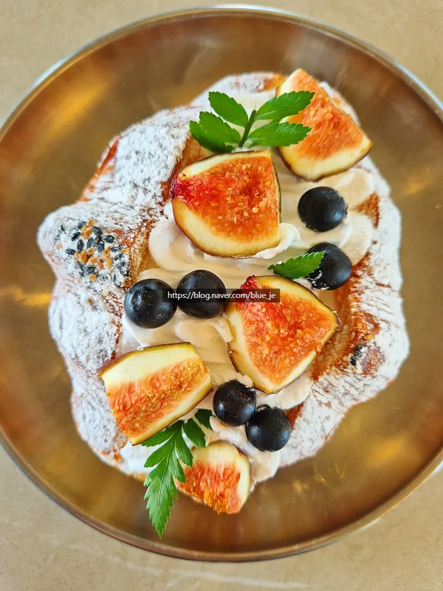 Fig cream croissant topped with fresh figs and blueberries