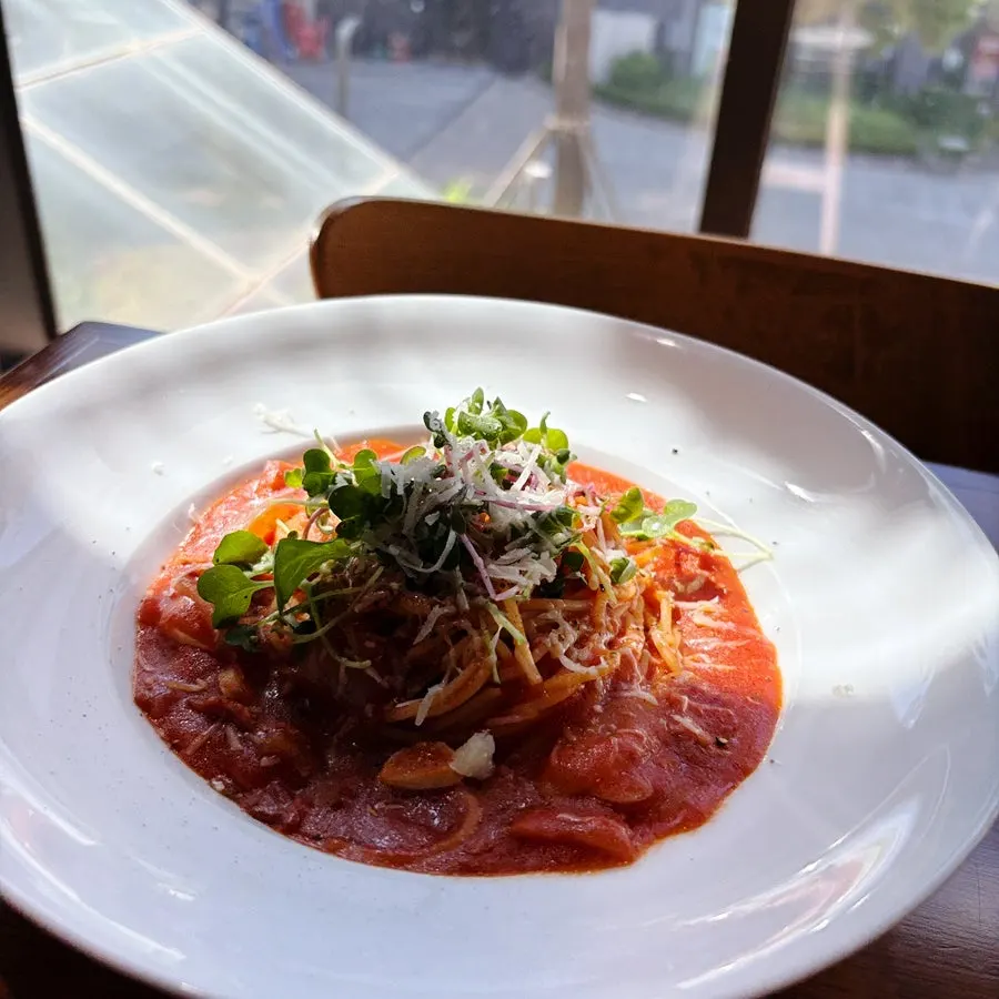 Forkful of bacon tomato pasta lifted from the plate