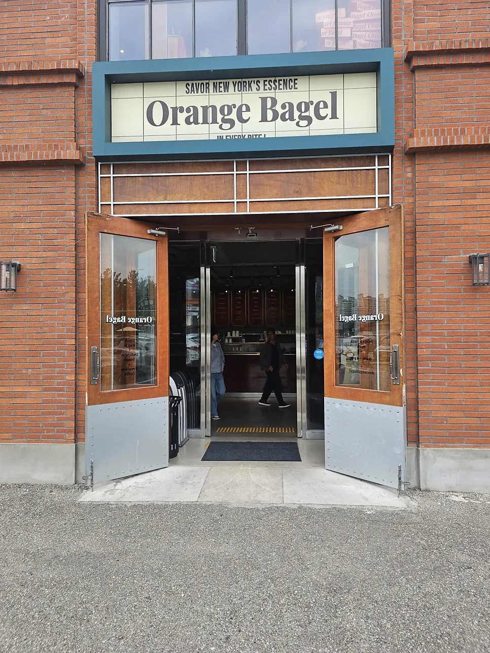 Entrance of Orange Bagel with hours posted