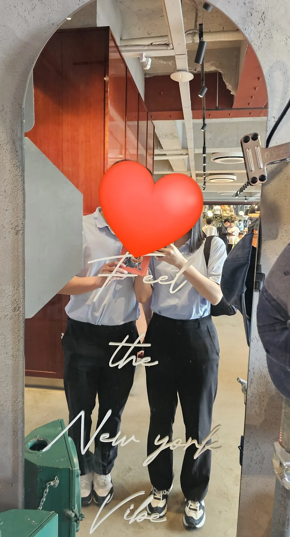 Couple's photo in front of the mirror at Orange Bagel