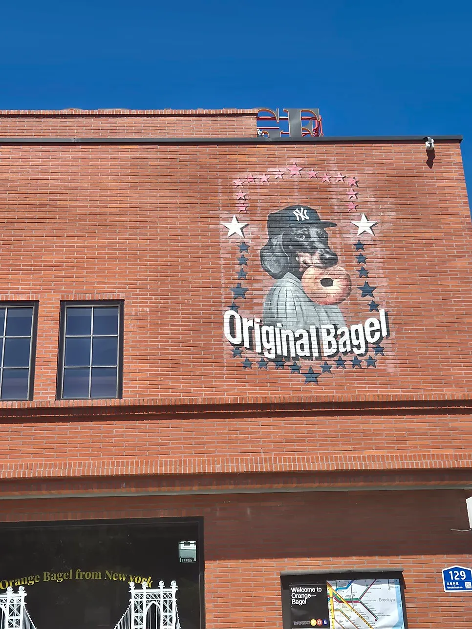 Red-brick building exterior and sign of Orange Bagel
