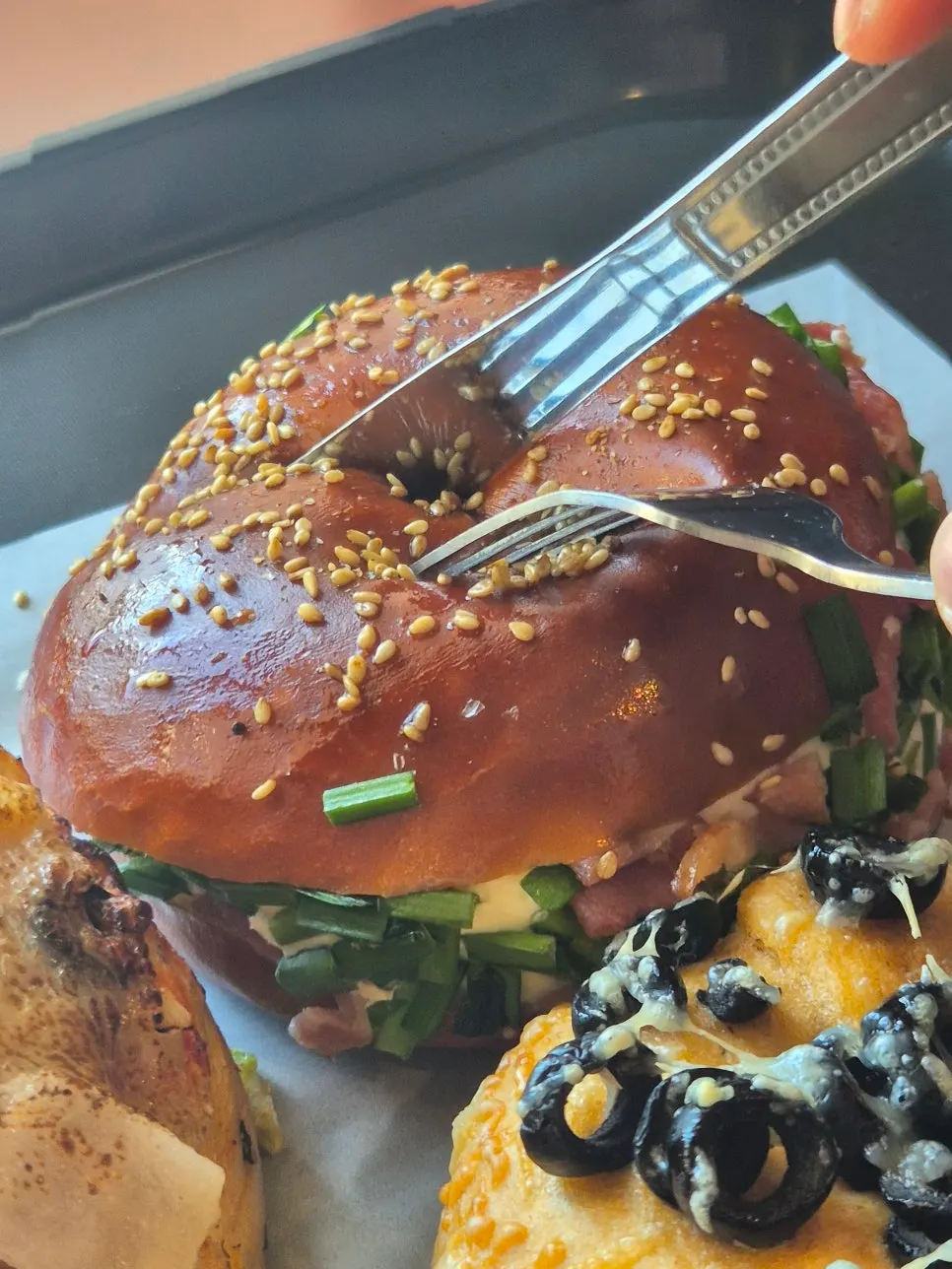Scallion cream bacon bagel studded with sesame seeds