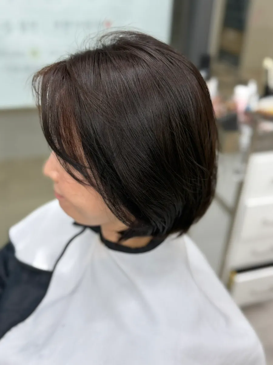Dark brown hair finished with S-curl styling