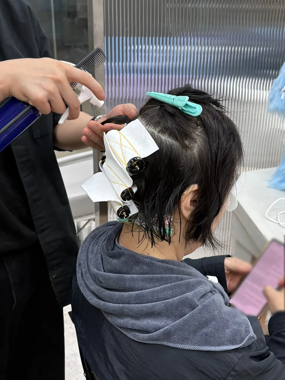 Applying perm solution and smoothing curly bangs