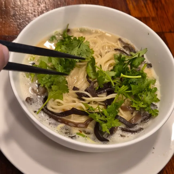 A bowl of ramen topped with cilantro