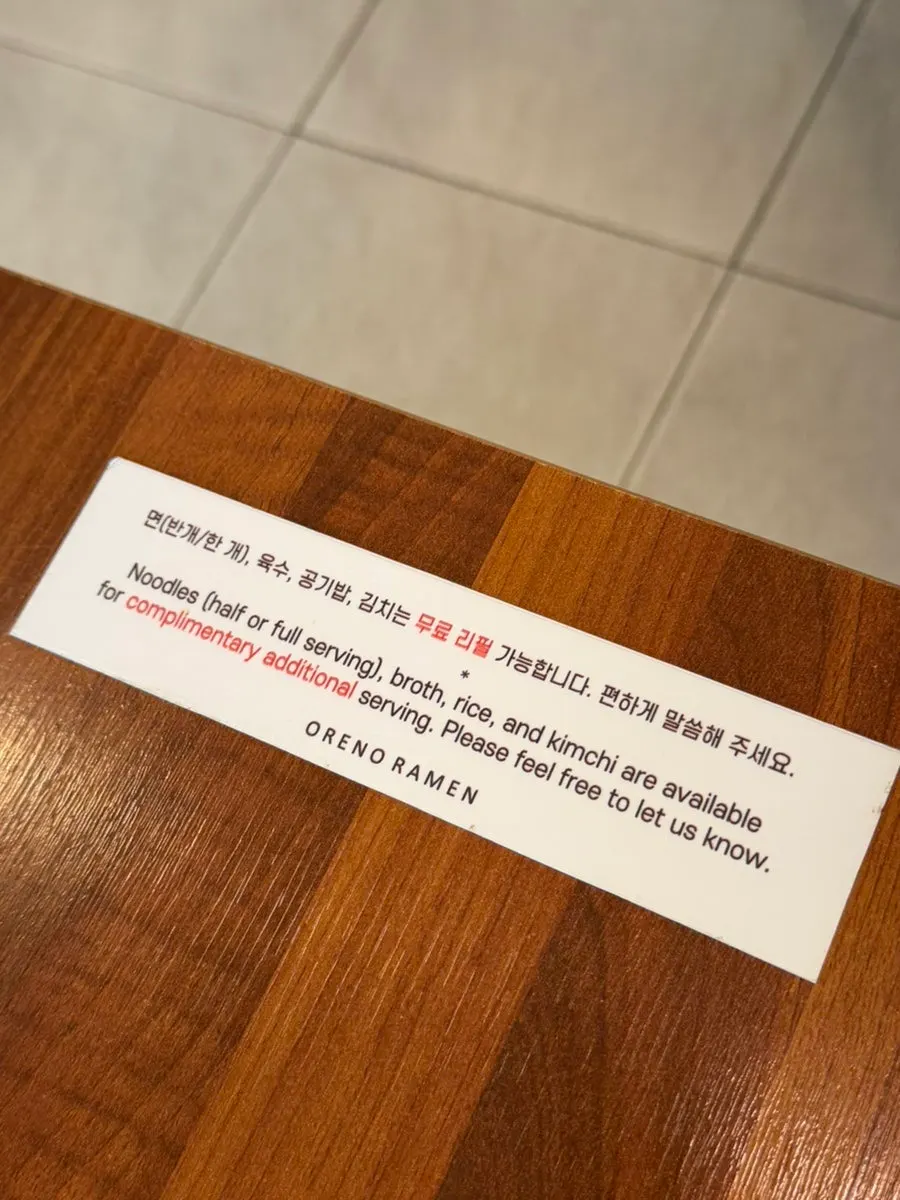 Sign about unlimited refills on noodles, rice, broth and kimchi