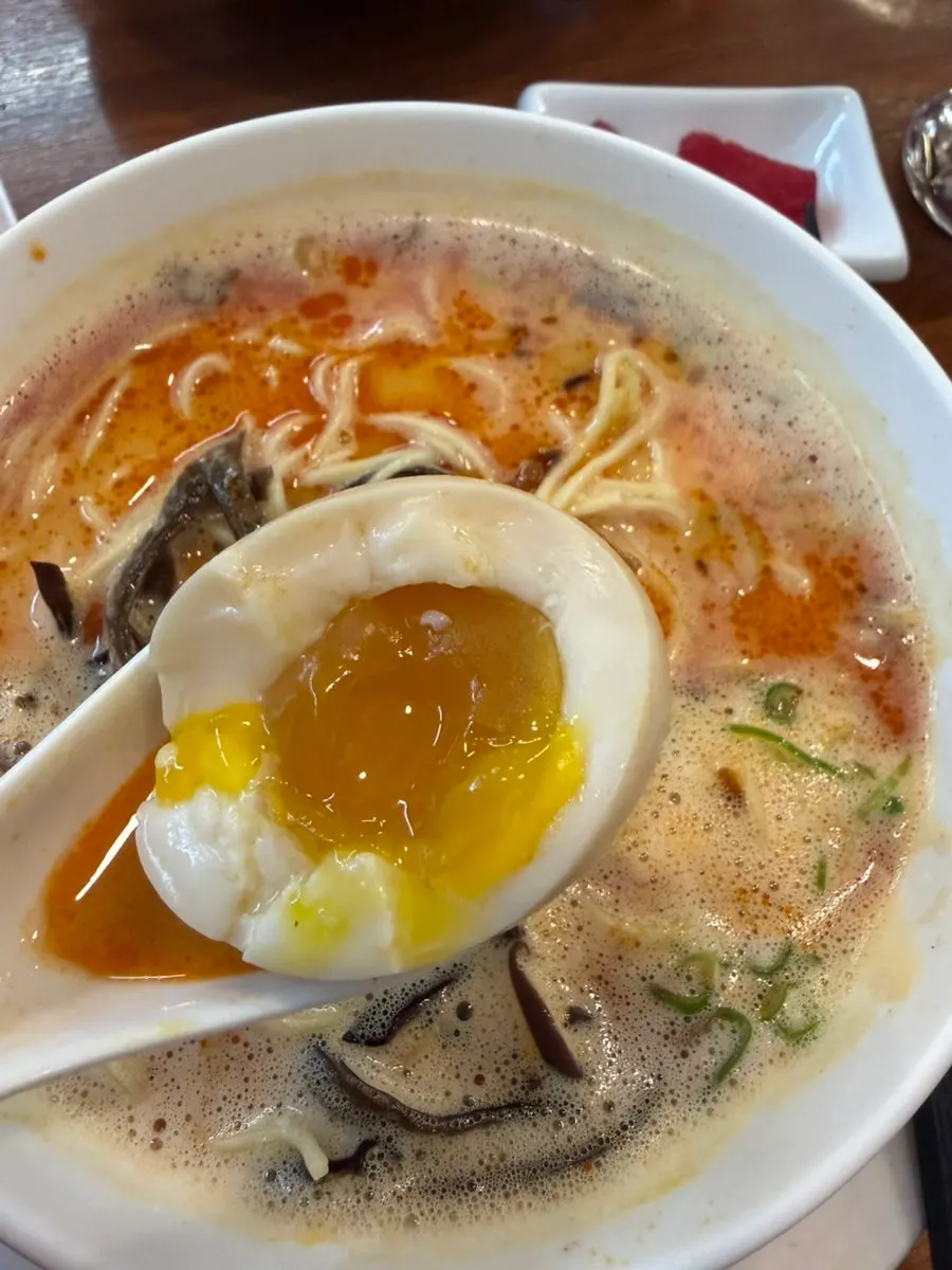 Soft-boiled egg halved next to the ramen broth