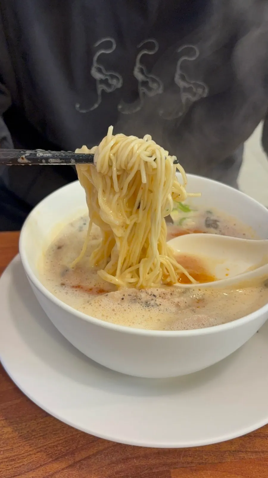 Red broth of karai paitan after the foam is skimmed off
