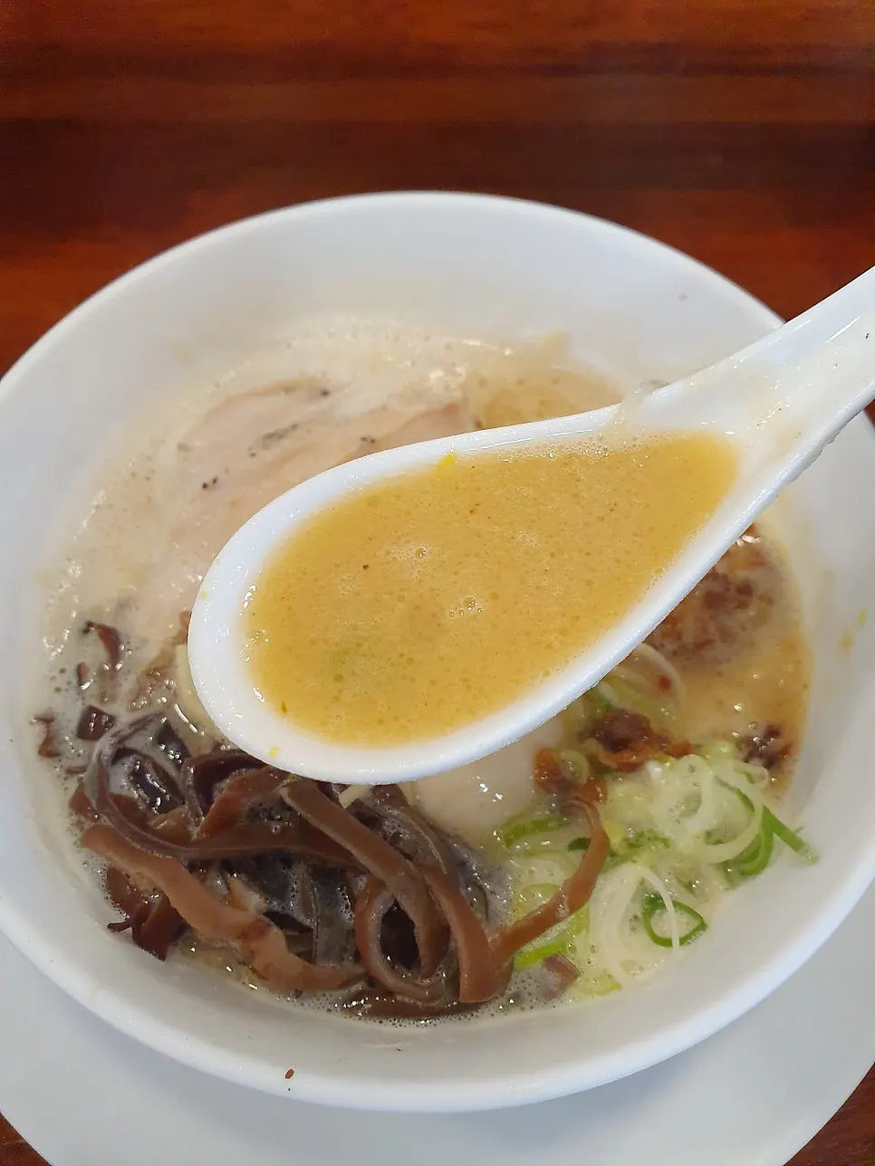 A bowl of tori paitan topped with foam