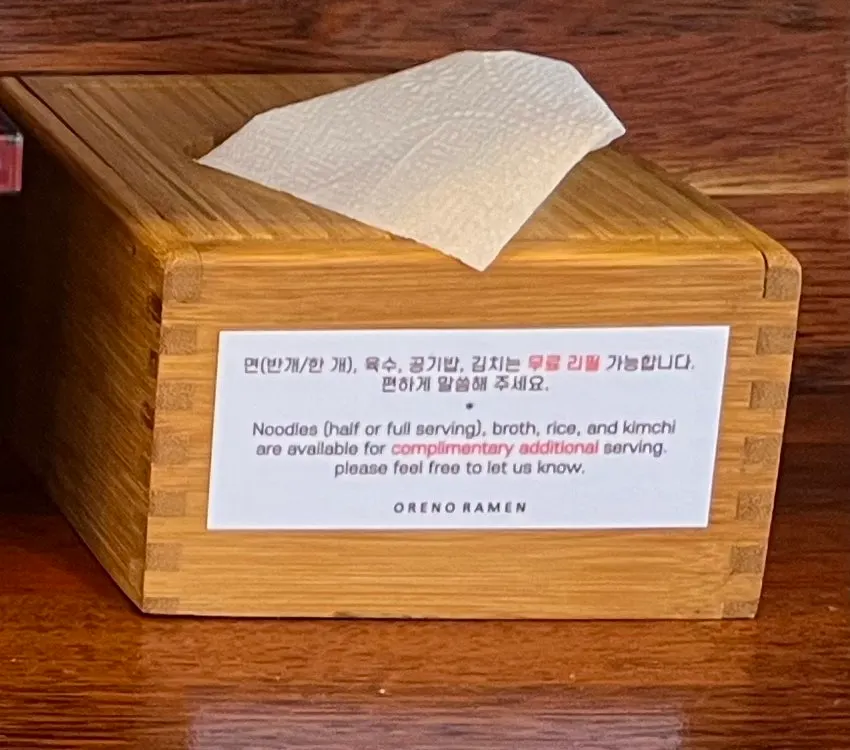 Sign explaining noodle, rice, and broth refills
