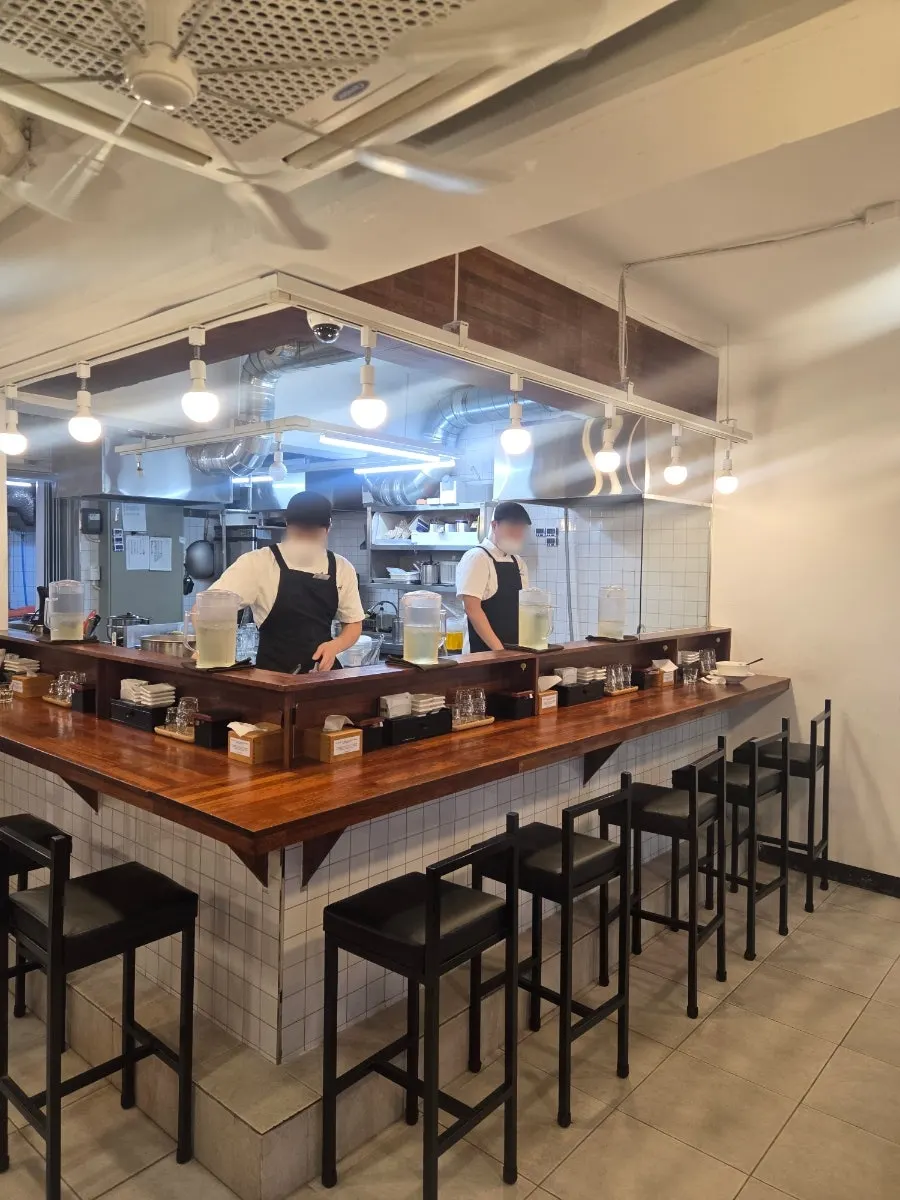 View of the open kitchen from a solo counter seat