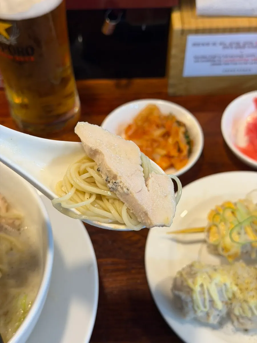 Thin ramen noodles lifted with chopsticks