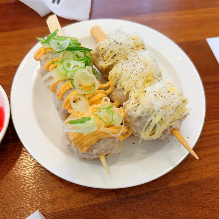 淋着不同酱汁和配料的鸡肉丸一份