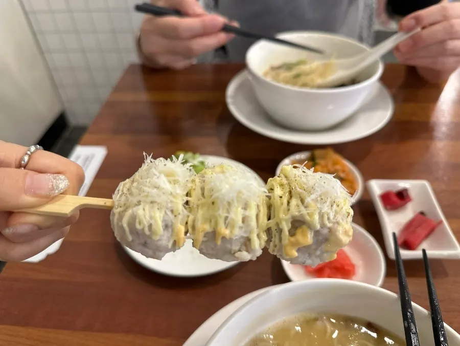 Picking up a mentaiko-scallion chicken skewer
