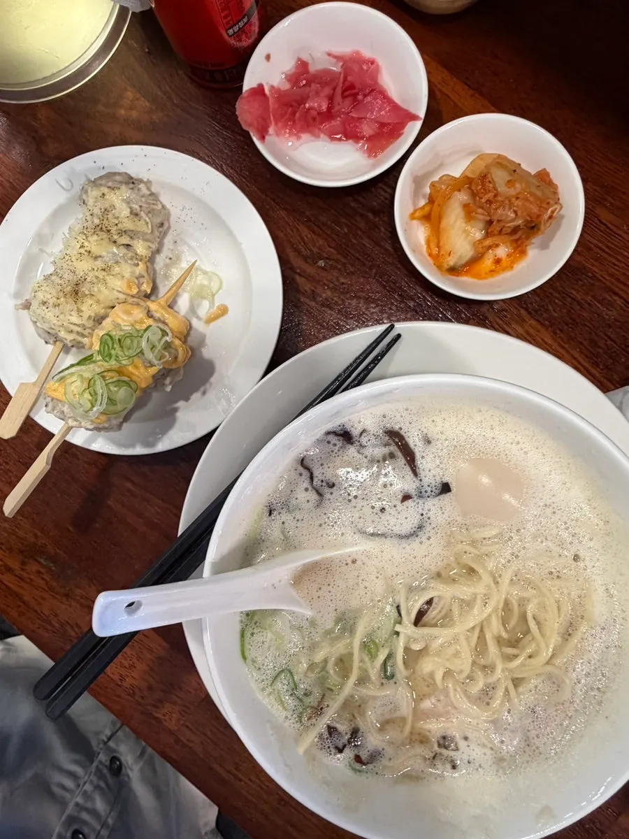 Sign explaining free refills on noodles, rice, and broth