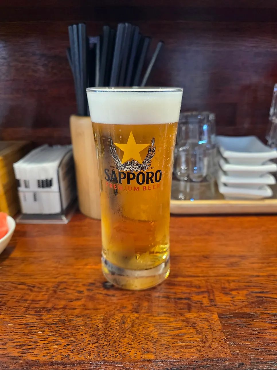 Glass of Sapporo draft beer served at the table