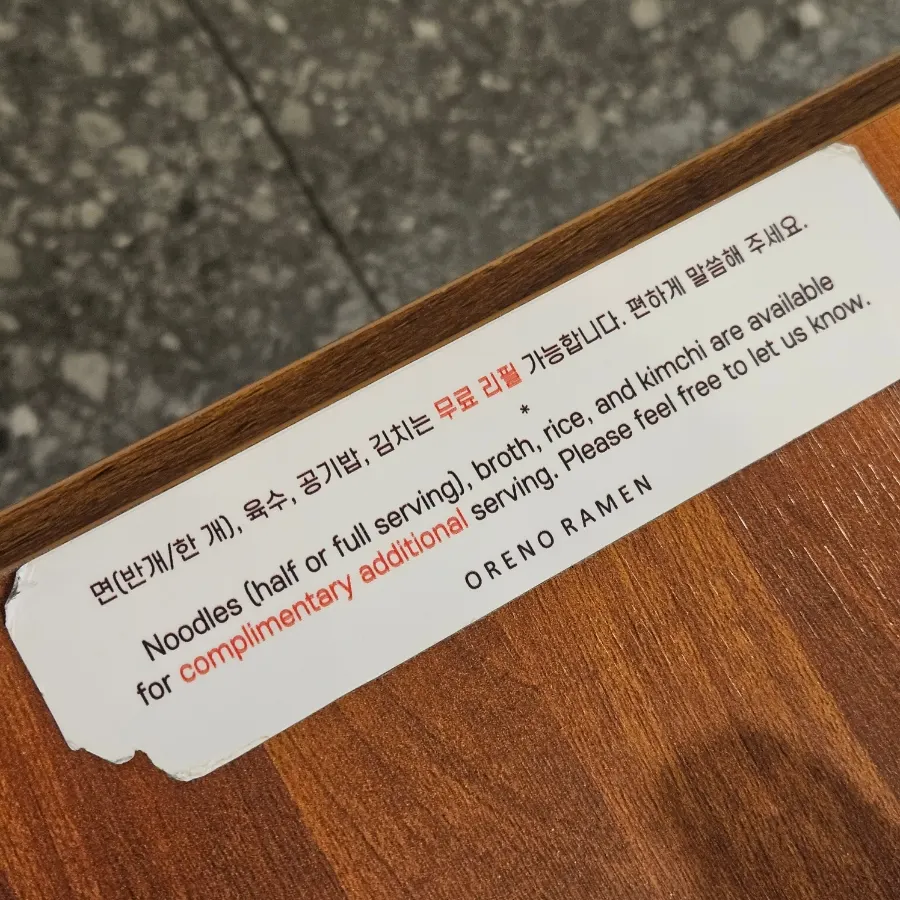 Sign explaining free refills on noodles, broth, and rice