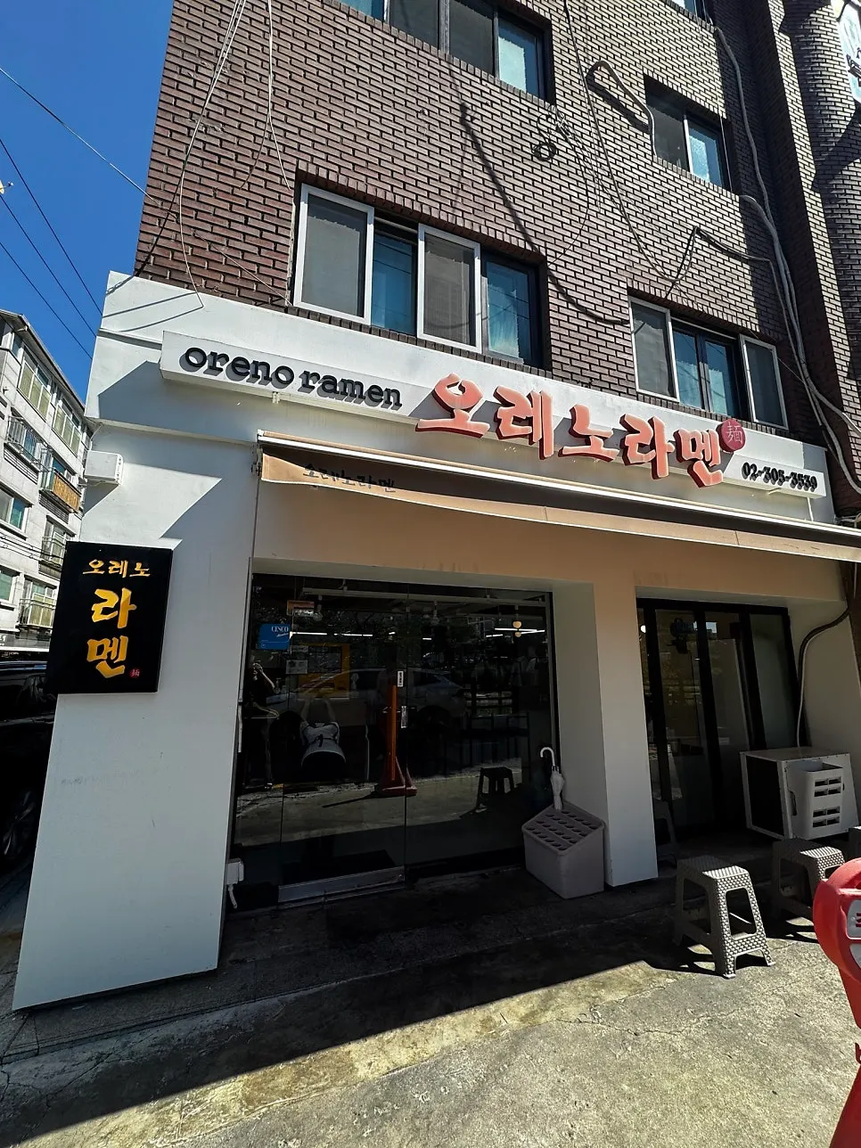Storefront with a white sign and black standing sign