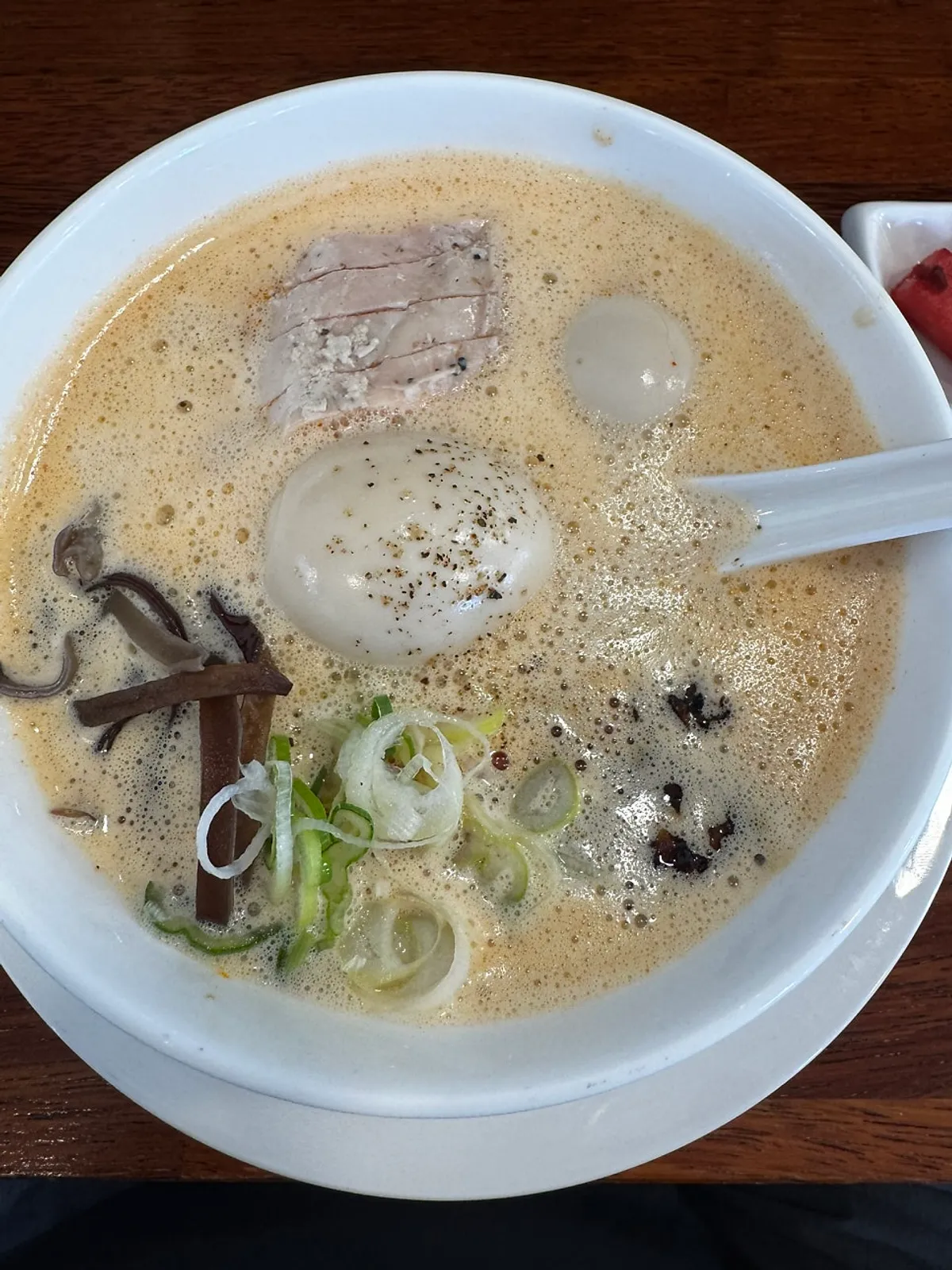 A bowl of tori paitan ramen covered in white foam