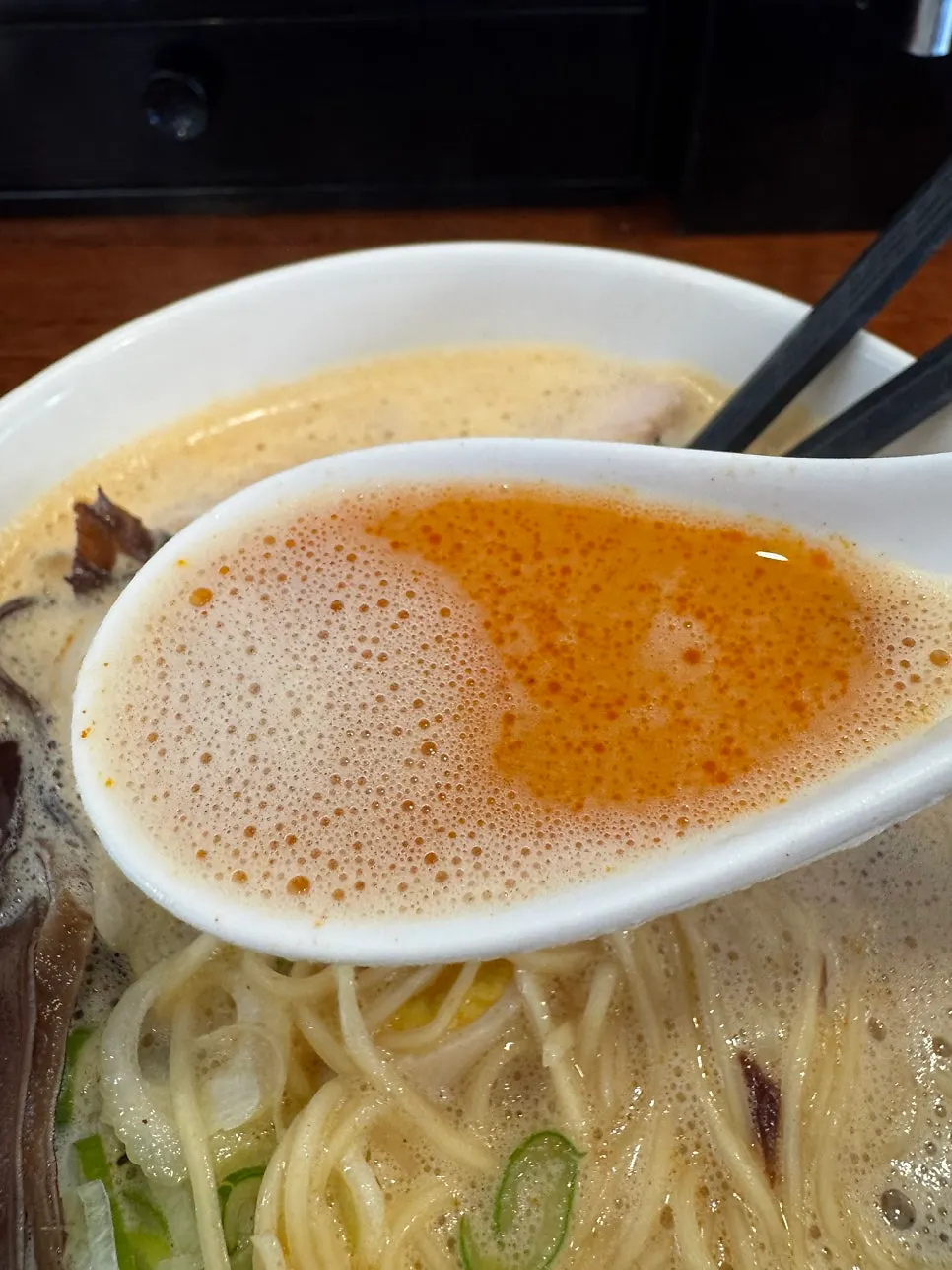 Pale chicken broth lifted on a spoon