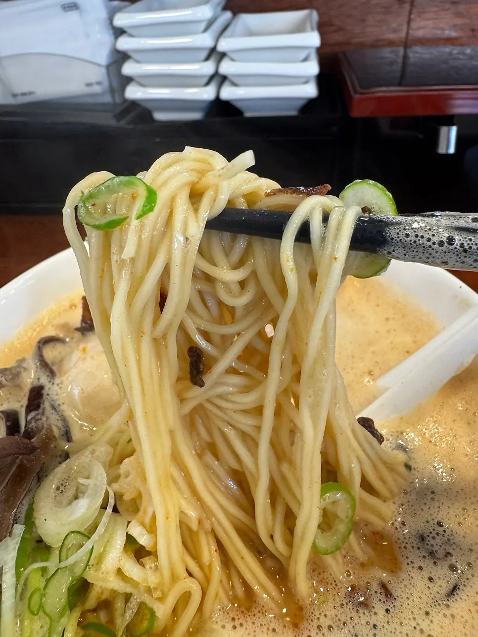 Ramen noodles lifted with chopsticks