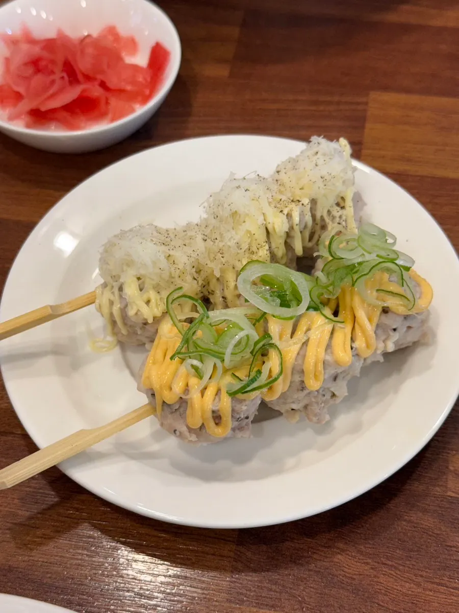 Mixed tsukune skewers topped with sauce and garnish