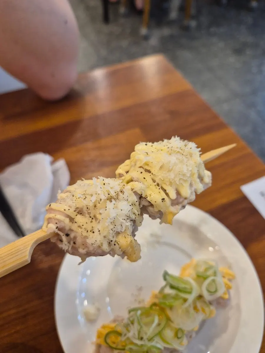 Mixed tsukune topped with garlic mayo and cheddar cheese