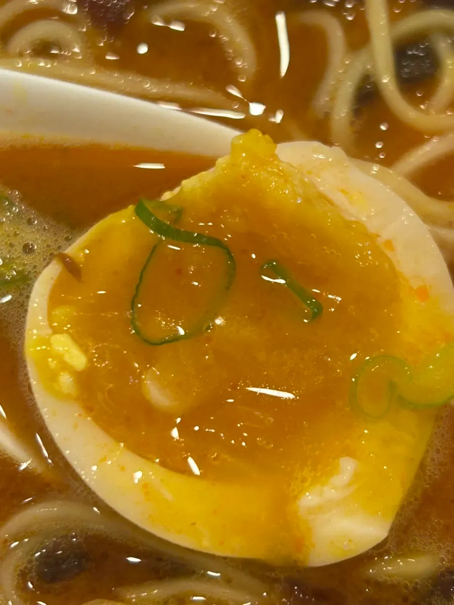 Popping the soft-boiled egg to eat with the broth