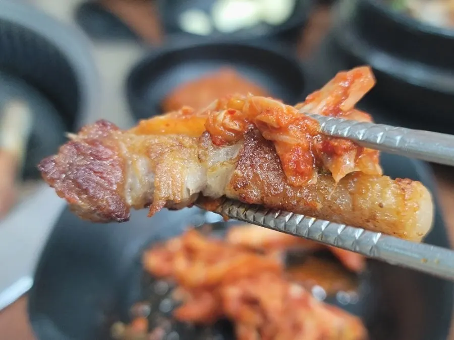 김치를 올린 흑돼지 구이 한 점