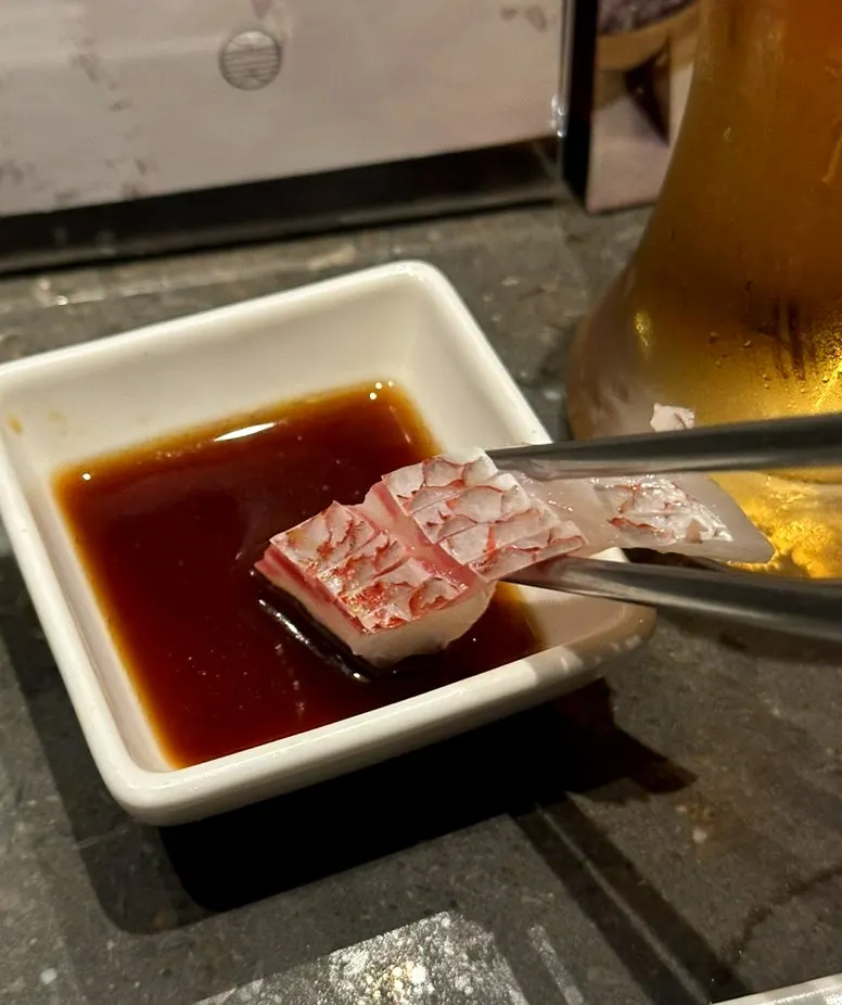 Sea bream sashimi served alongside Yebisu draft beer