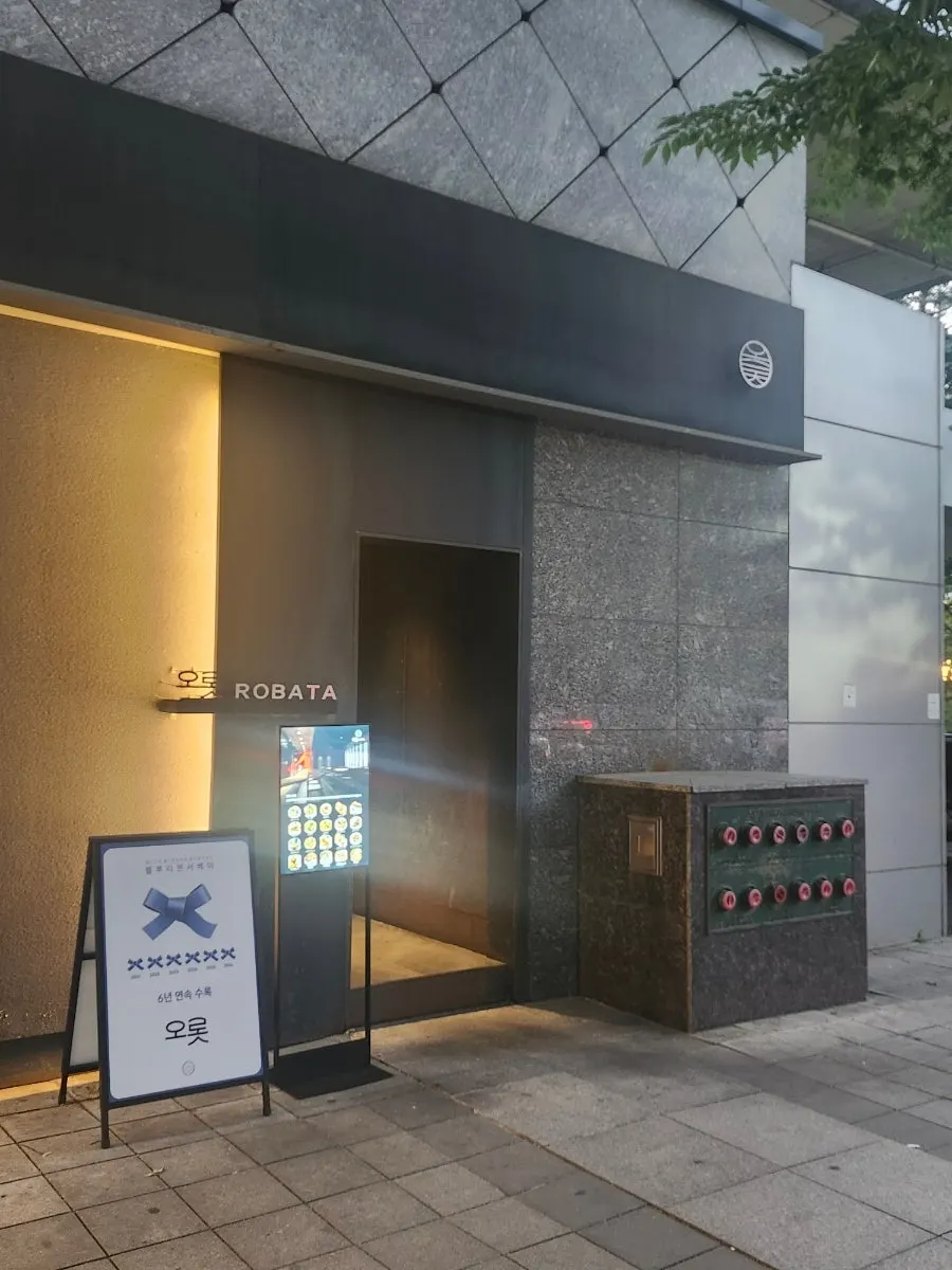 어두운 외벽과 조명으로 정리된 오롯로바타 입구