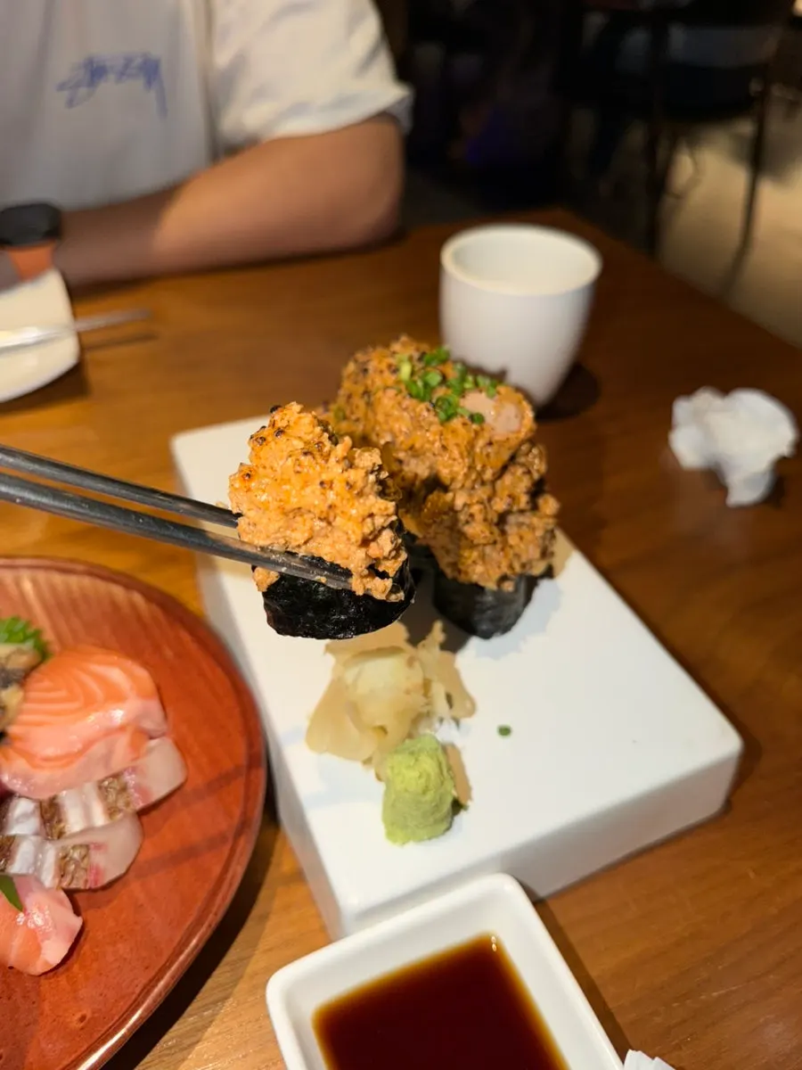 Bocado de ankimo maki sobre alga nori y arroz