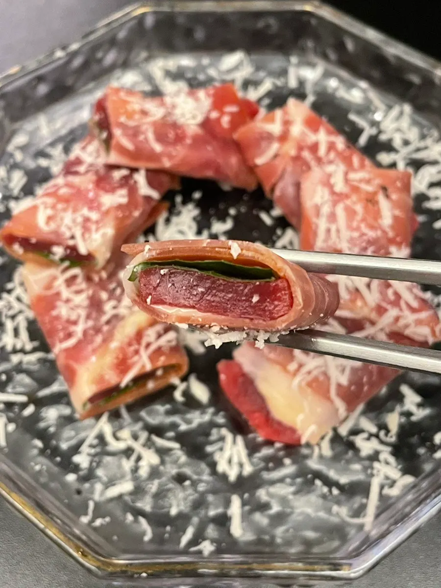 A bite of jamón tuna with truffle sauce and shiso