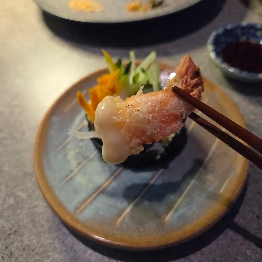 A piece of futomaki dipped in truffle sauce