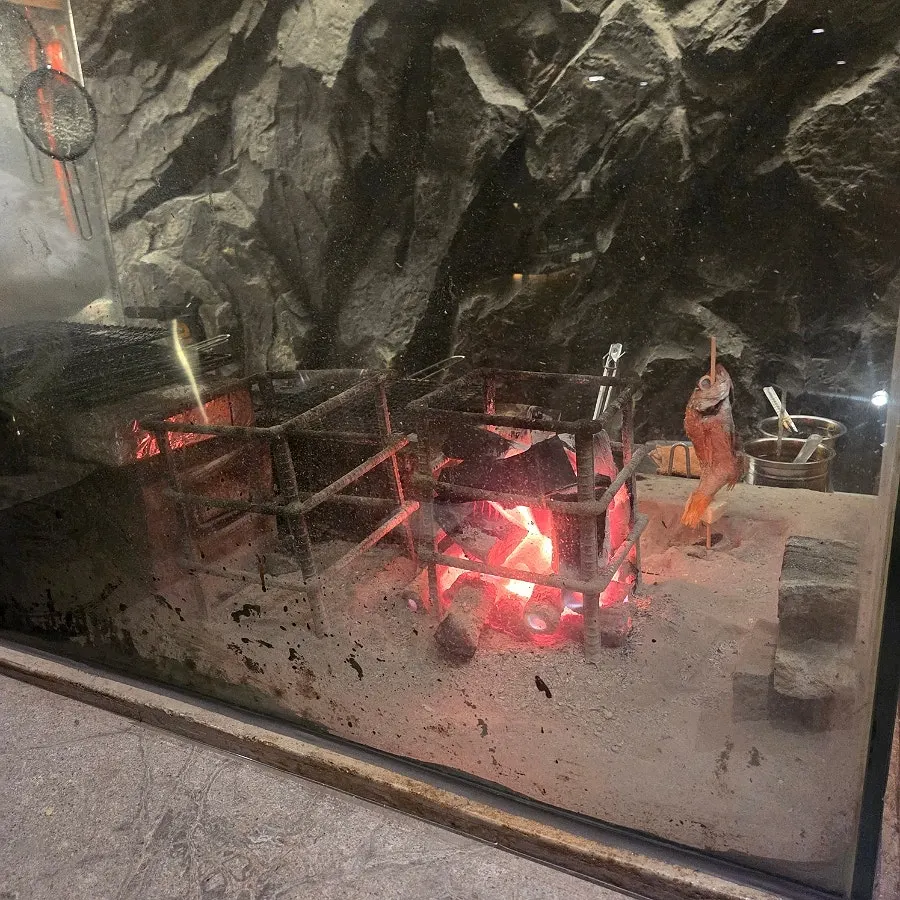 Fish being grilled over charcoal at Osa Cheongdam