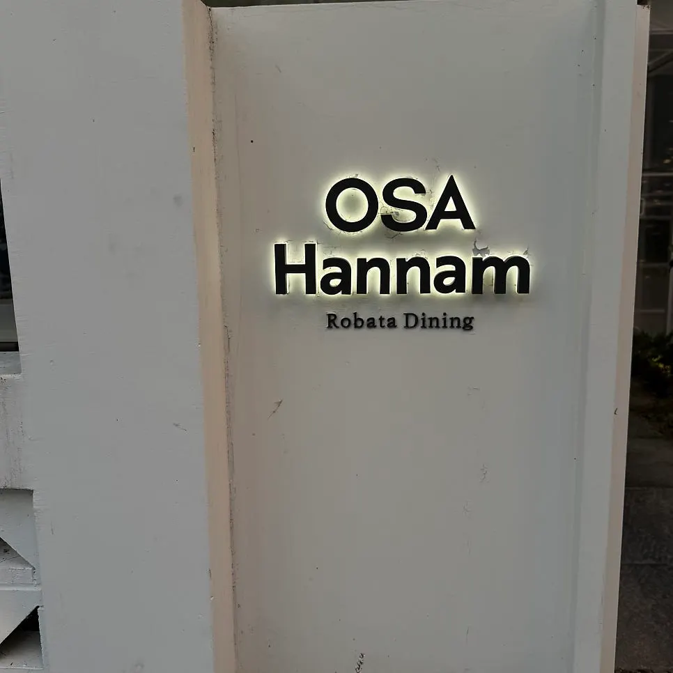 Triangle-patterned white brick wall and the OSA Hannam sign