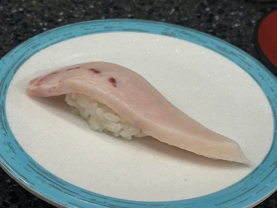 A sushi plate with a thick cut of fish on top