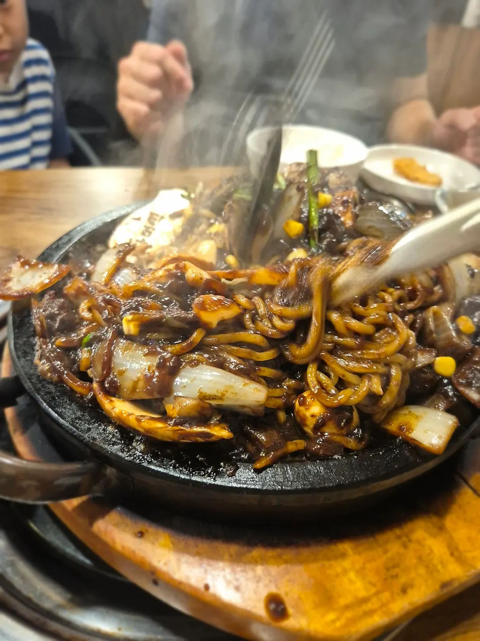Close-up of sizzling jjajang on the stone plate