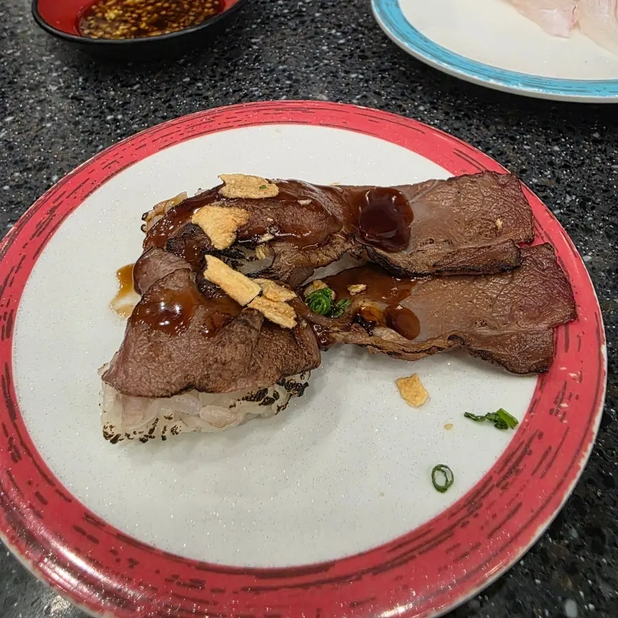 Beef steak sushi on the conveyor rail