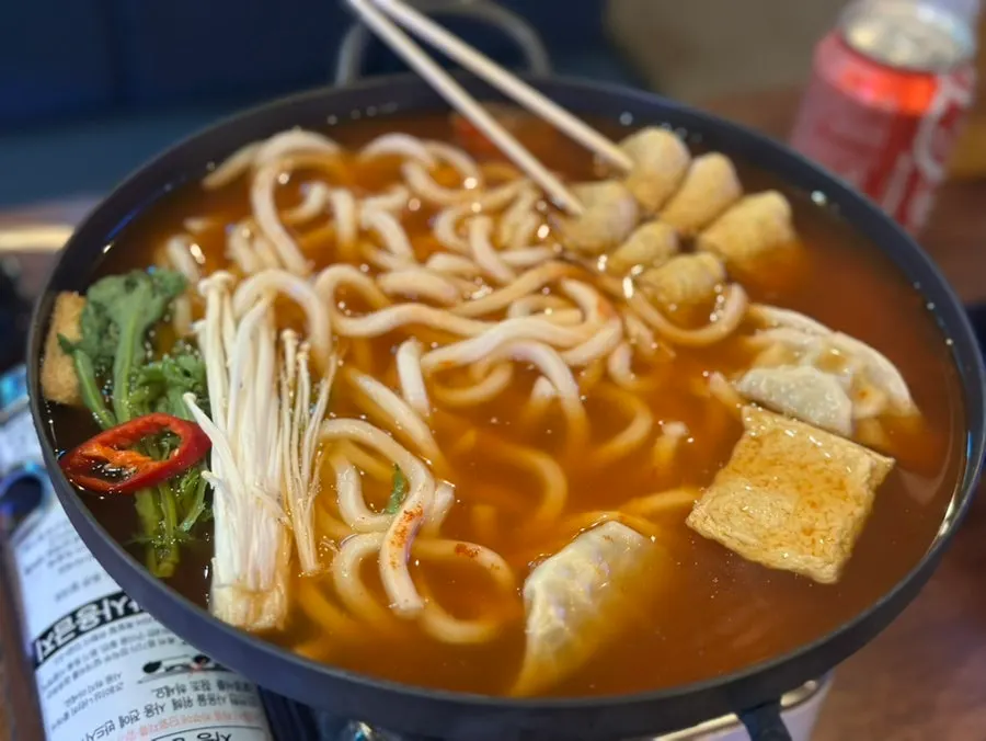 Pot of kimchi eomuk udon loaded with ingredients