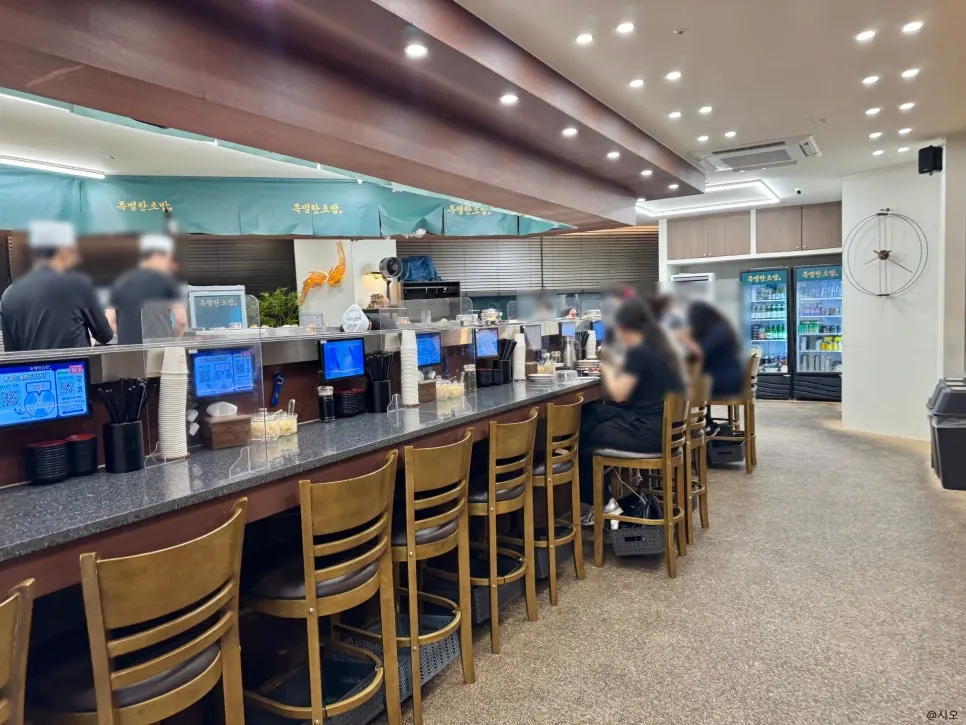コの字型のバー席中心の回転寿司店の内部