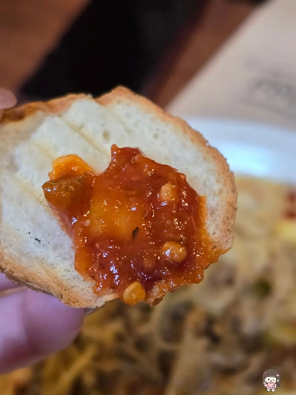 A piece of baguette dipped in sauce alone