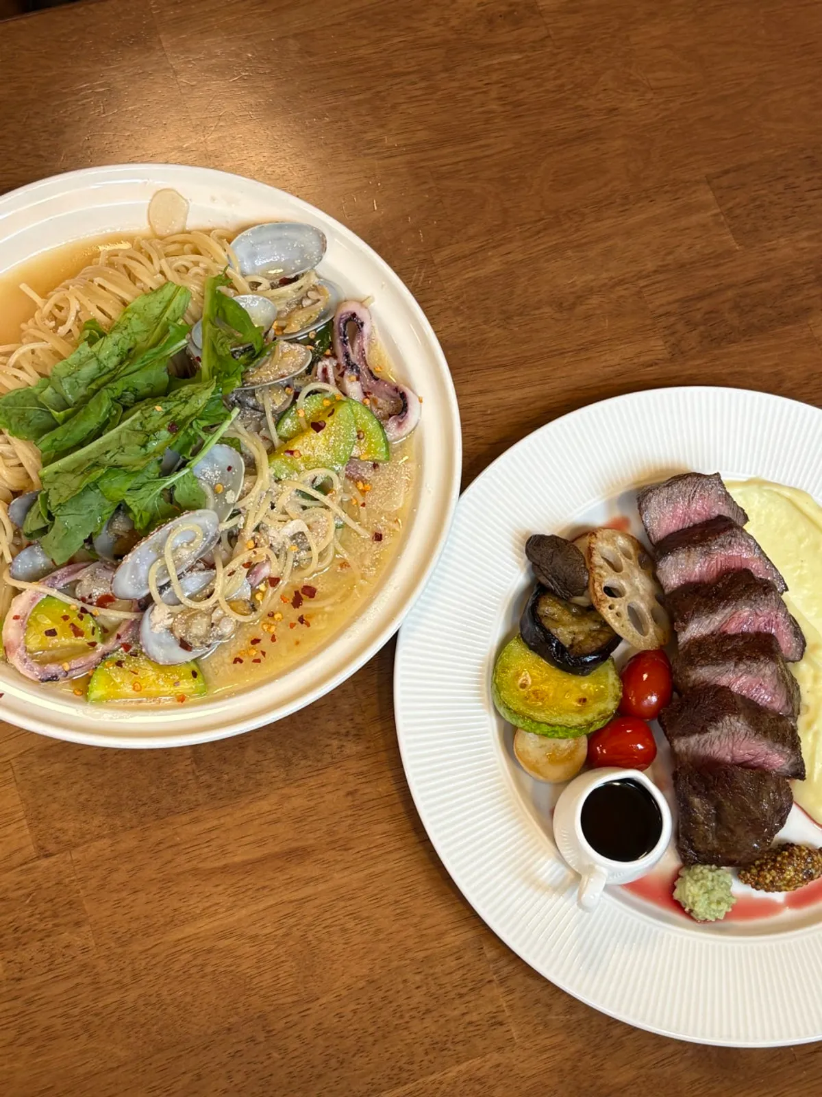 Table with steak and pasta served at the same time