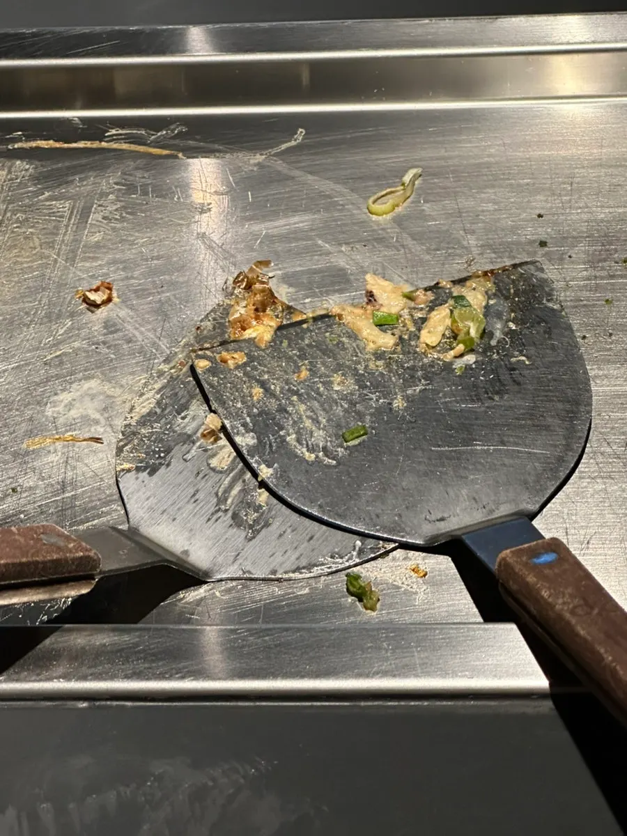 Cross-section of okonomiyaki topped with bonito flakes and scallions