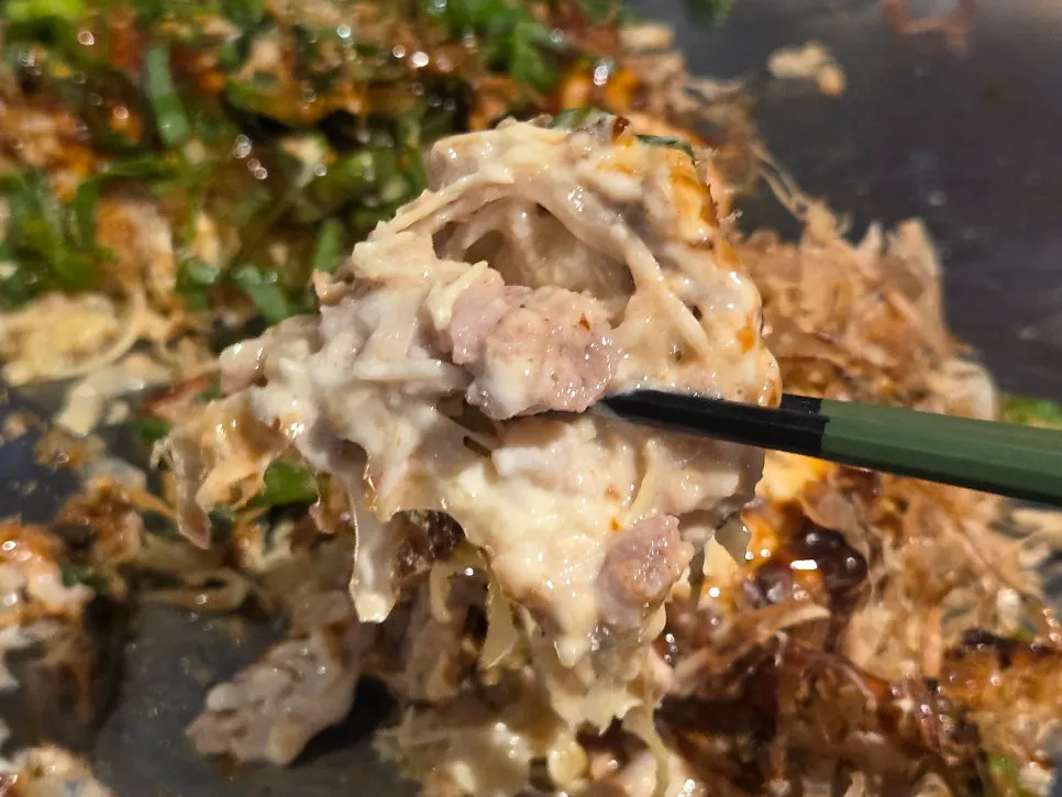 A generously filled slice of okonomiyaki
