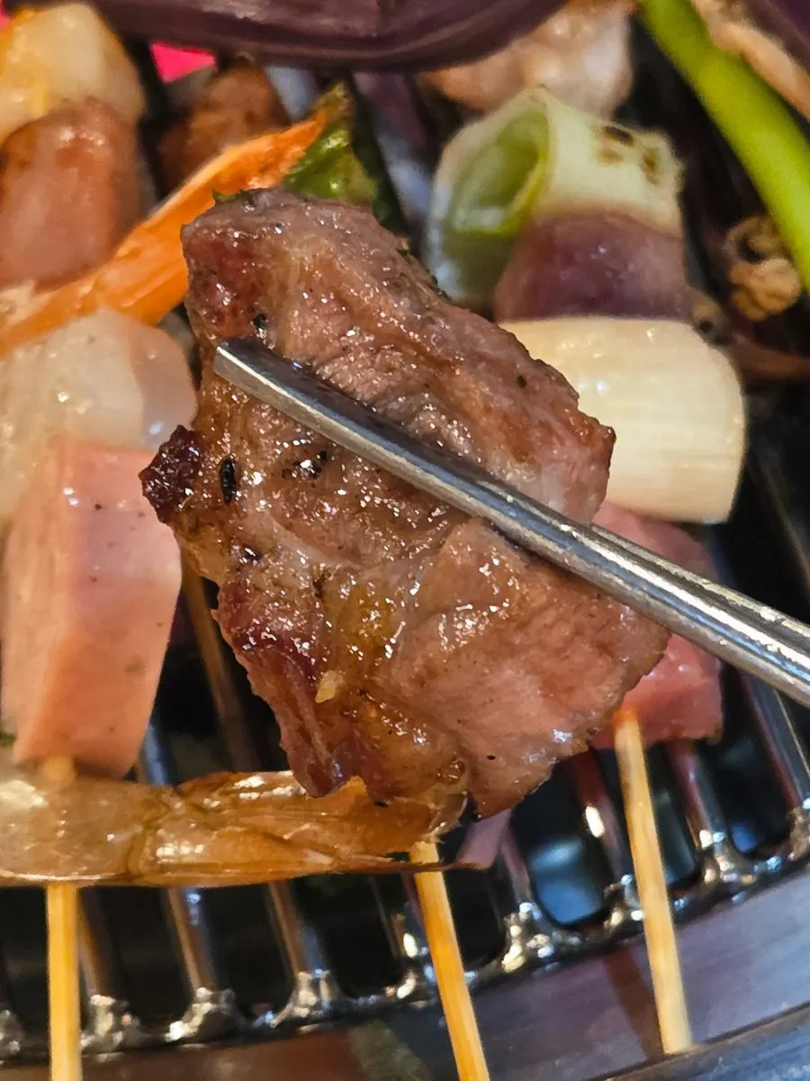 A piece of pork belly dipped in onion sauce