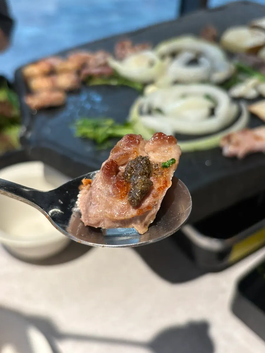 A piece of black pork samgyeopsal on lettuce
